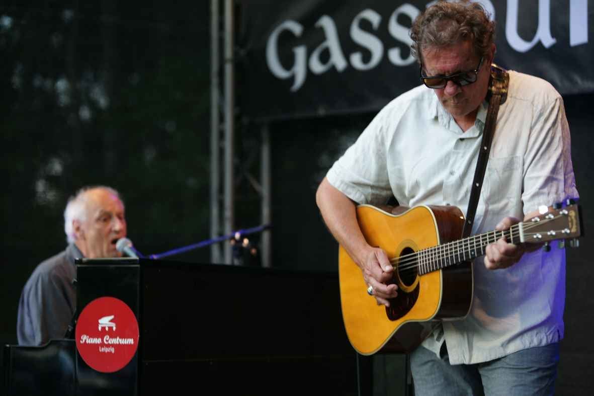 Das Liedertour-Festival, 30.07.2021: Paul Millns am Piano und Butch Coulter mit Gitarre vor dem Banner „Gassmühle“